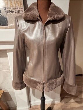 Henig women’s furs, taupe leather jacket with fur collar, cuffs, and bottom.